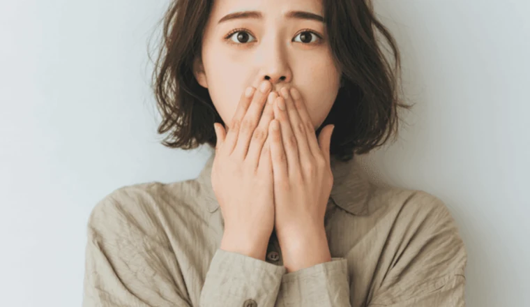 갑작스러운 상황에 놀라 두 손을 입에 모은 성인 여성
